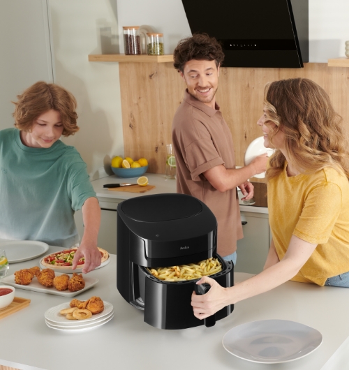 Rodzina przygotowująca posiłek w kuchni z użyciem frytkownicy Amica stojącej na blacie