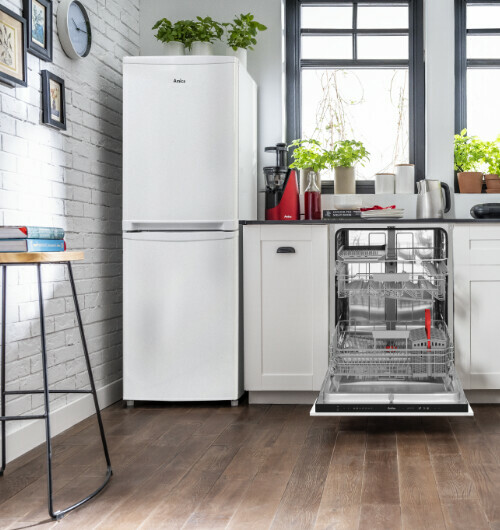 Nowoczesna kuchnia Amica, biała lodówka obok zabudowy, na środku zmywarka z otwartymi drzwiami i wysuniętymi koszami