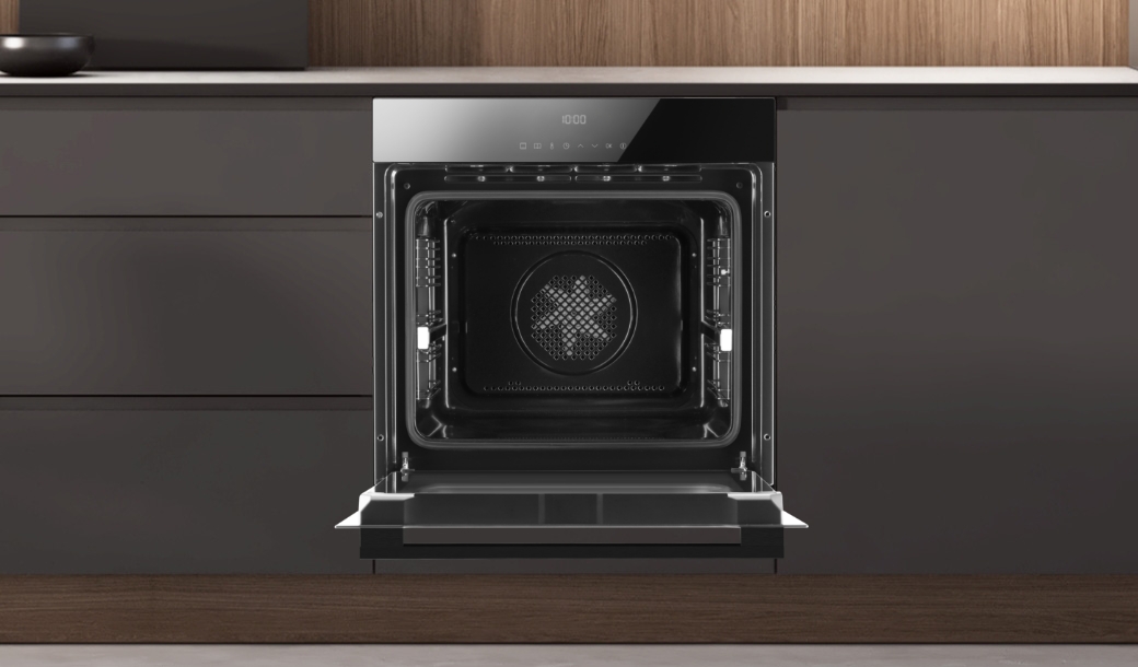 Otwarty piekarnik Amica w ciemnej zabudowie kuchennej bez uchwytów